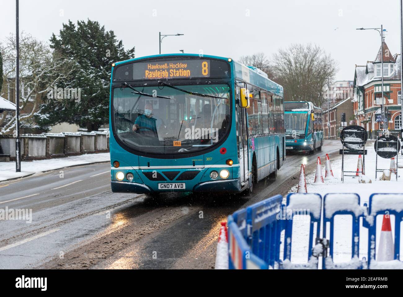 Arriva Bus-Service auf eisiger Straße in Southend on Sea, Essex, Großbritannien, mit Schnee von Storm Darcy. Schlechte Straßenverhältnisse. Fahrer trägt Gesichtsmaske Stockfoto