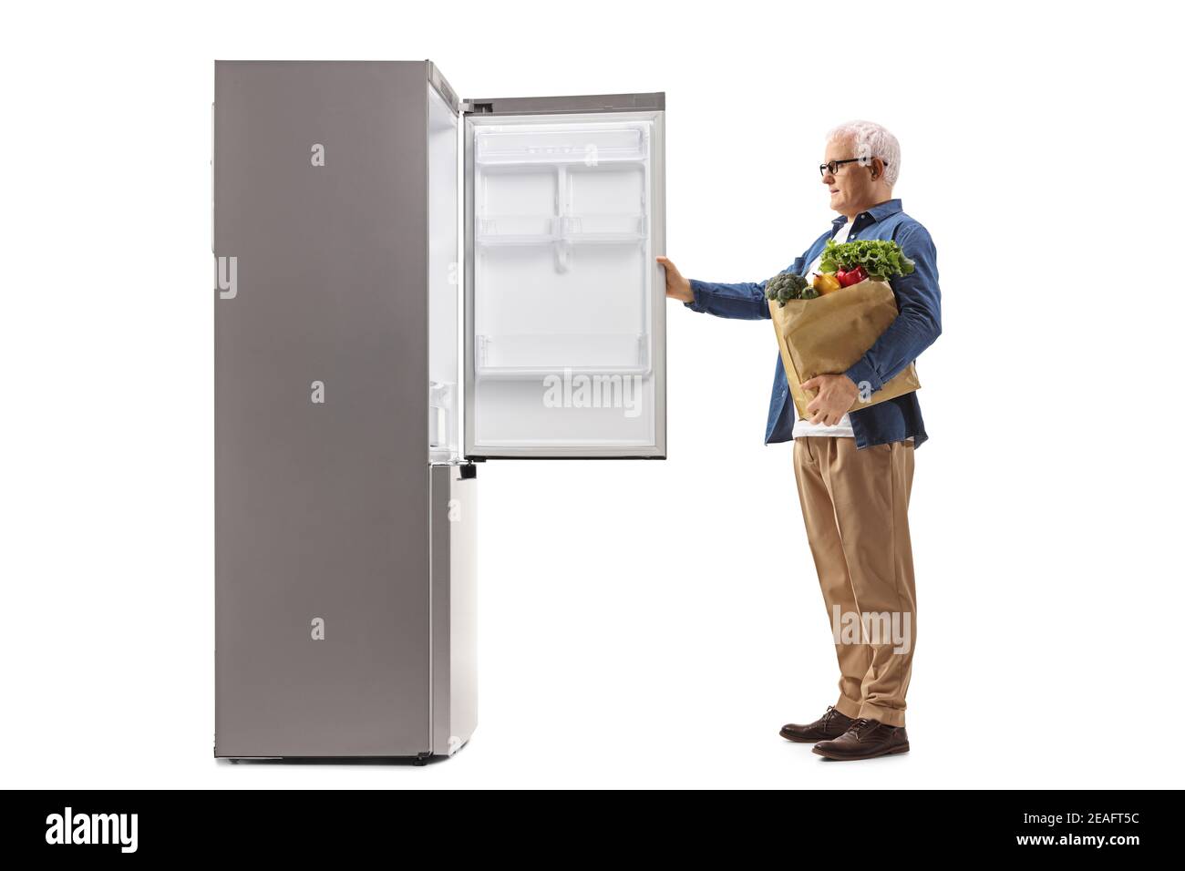 In voller Länge Profilaufnahme eines reifen Mannes mit einem Lebensmitteltasche öffnet einen Kühlschrank isoliert auf weißem Hintergrund Stockfoto