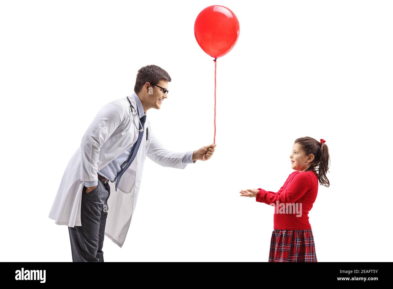 Doktor, der einem kleinen Mädchen isoliert einen roten Ballon gibt Auf weißem Hintergrund Stockfoto