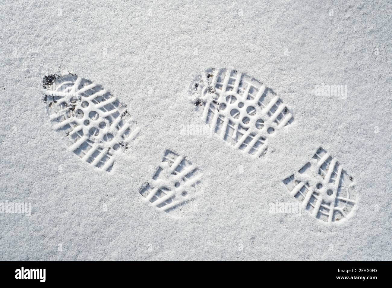 Klar definierte Fußabdrücke / Abdrücke im Neuschnee von Gummi Lug Sohlen mit tiefen Einbuchtungen von Bergsteigerschuhen / Wandern Stiefel im Winter Stockfoto