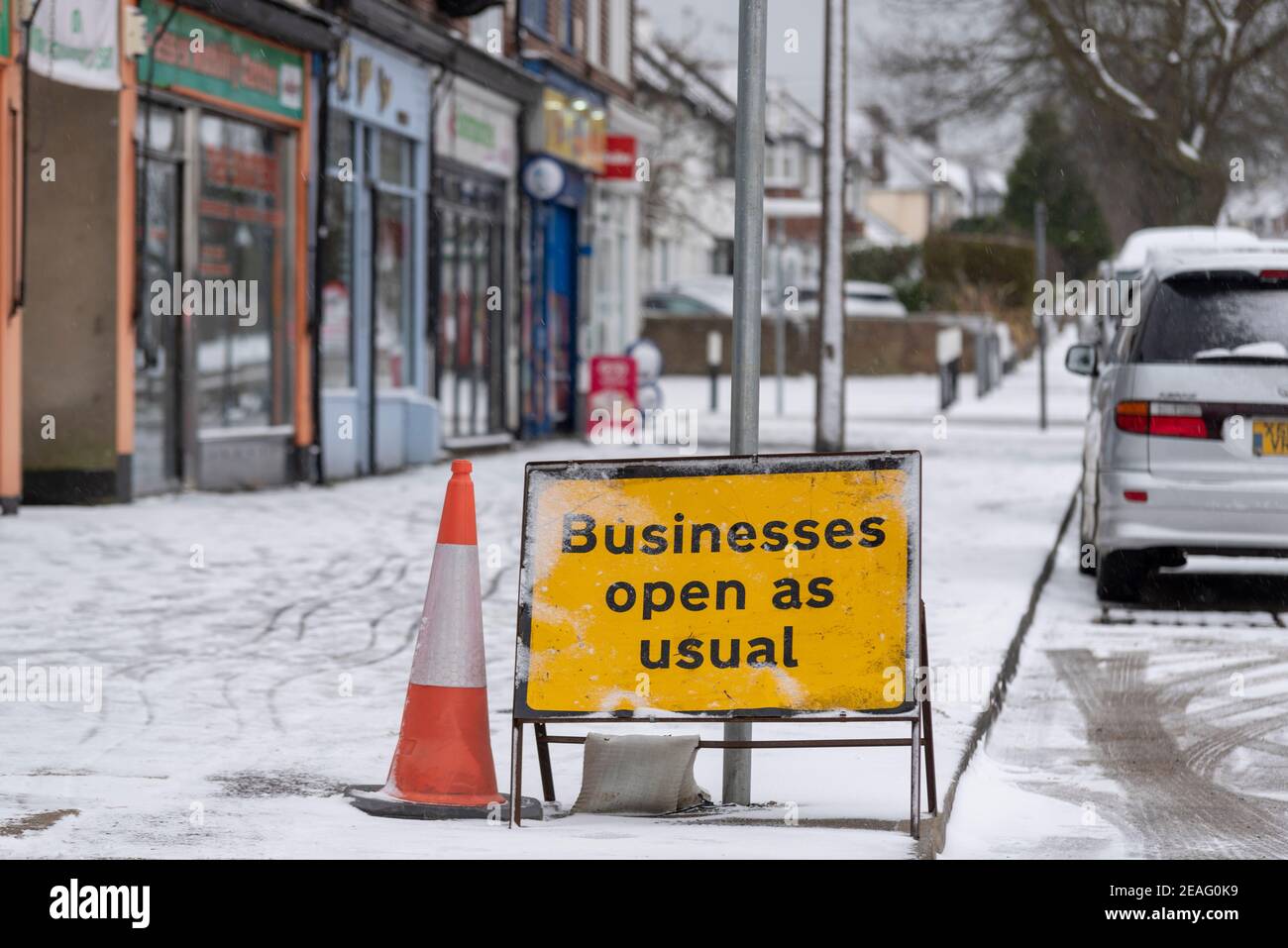 Unternehmen öffnen wie gewohnt Schild an Reihe von Geschäften in Southend on Sea, Essex, Großbritannien, mit Schnee von Storm Darcy. Die meisten geschlossen wegen COVID 19 Sperre. Eisig Stockfoto