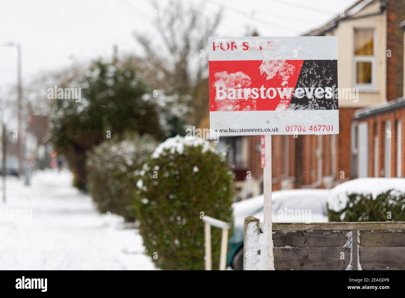 Gefrorener Immobilienmarkt. Bairstow eves zum Verkauf Schild in Southend on Sea, Essex, UK, mit Schnee von Storm Darcy. Immobilienagentur. Häuser Stockfoto