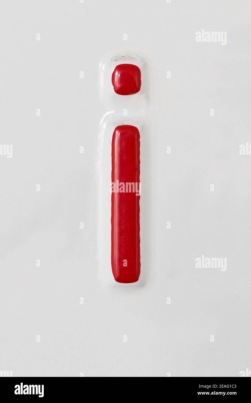 Geprägter roter Buchstabe i auf einem weißen Blechteller Stockfoto