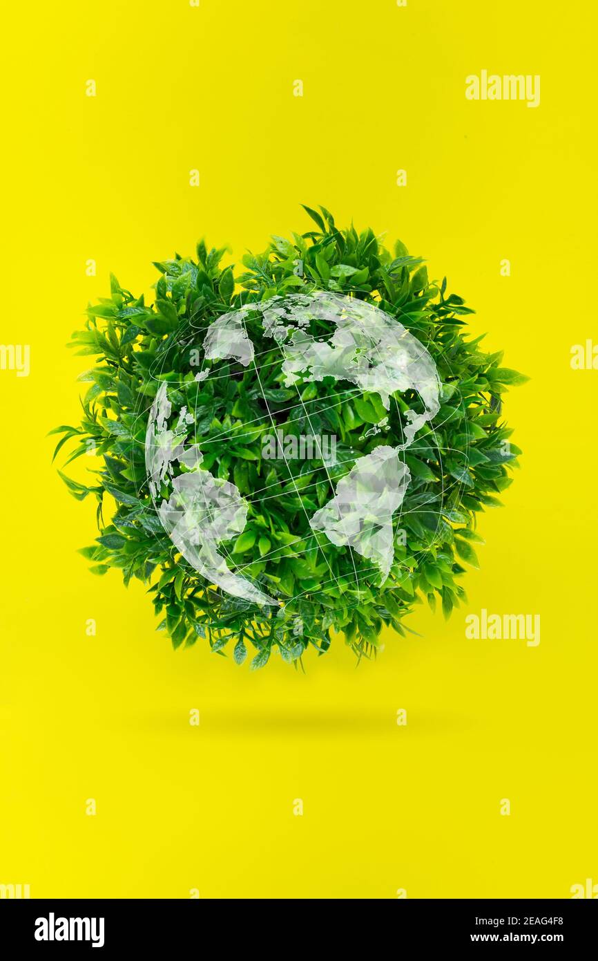 Weltumwelttag. Ökologisches Konzept-EIN Globus aus Gras auf einem gelben Hintergrund. Umweltfreundlicher Planet Stockfoto