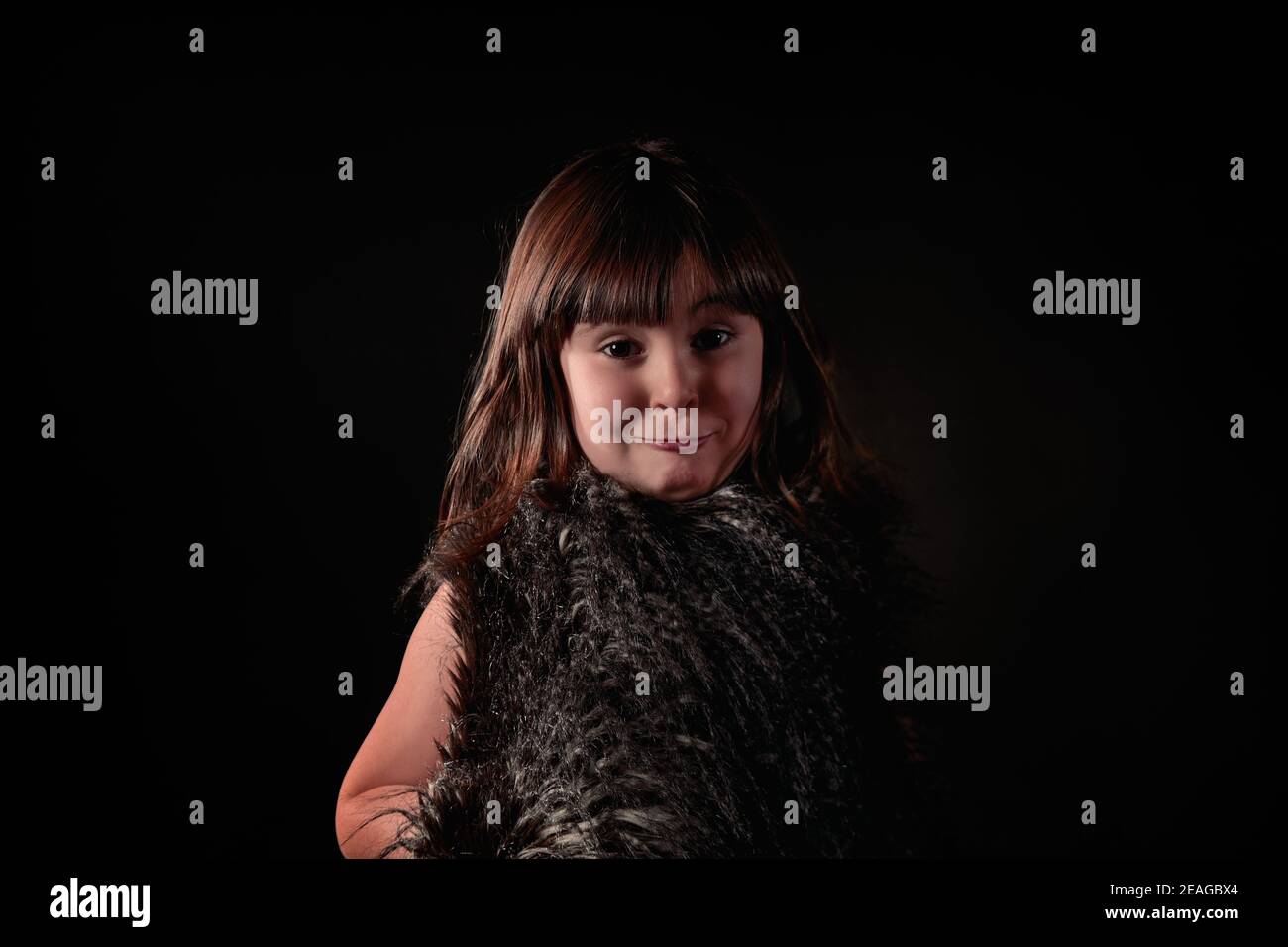Elegante vier Jahre alte kaukasische Mädchen in Federweste gekleidet Mit entzückenden und liebenswerten Ausdruck Porträt Blick auf die Kamera Stockfoto