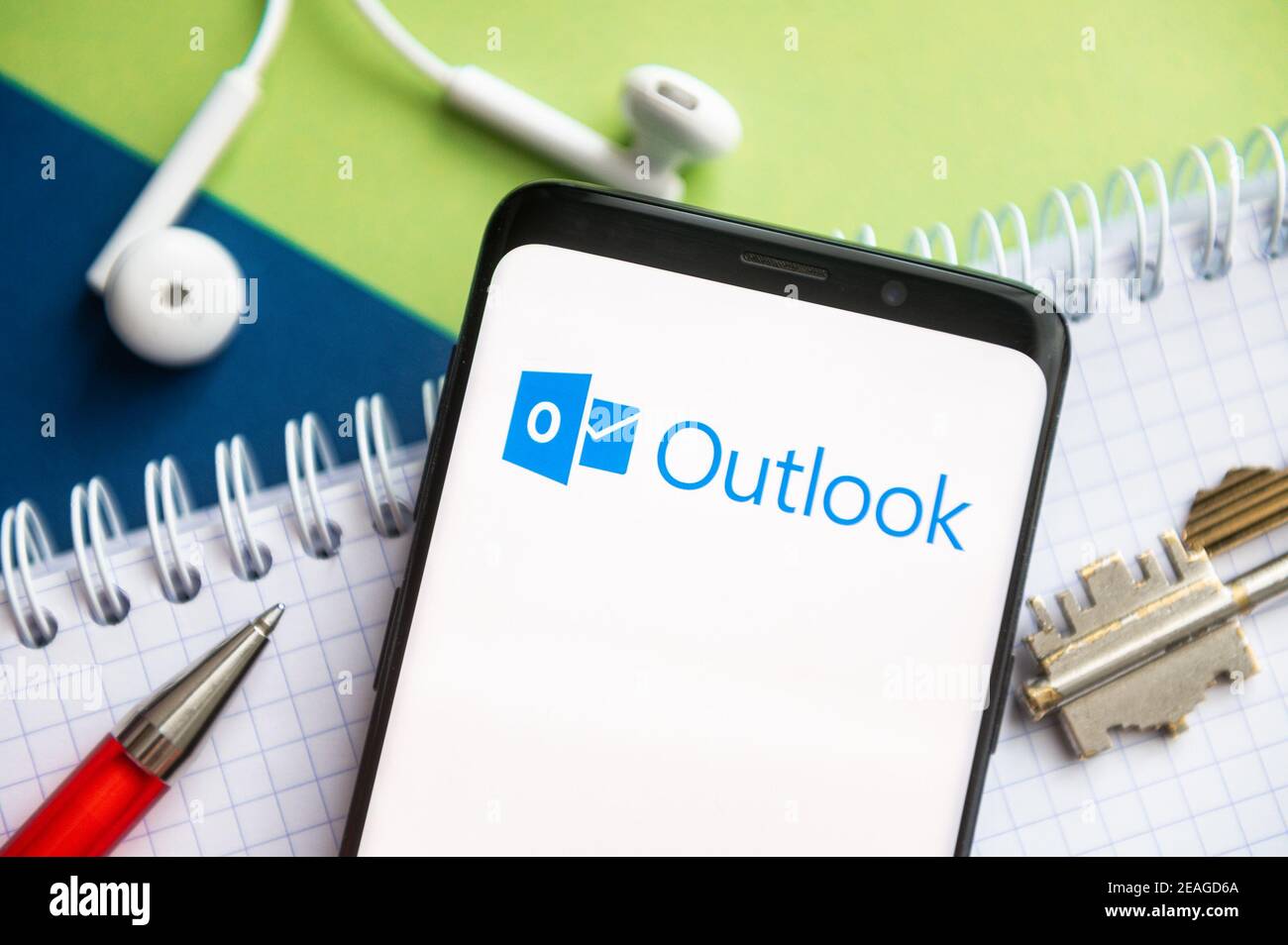 Polen. Februar 2021, 9th. In dieser Abbildung wird ein Microsoft-Logo von Outlook auf einem Smartphone mit Stift, Schlüssel, Buch und Headsets im Hintergrund angezeigt. Kredit: Mateusz Slodkowski/SOPA Images/ZUMA Wire/Alamy Live Nachrichten Stockfoto