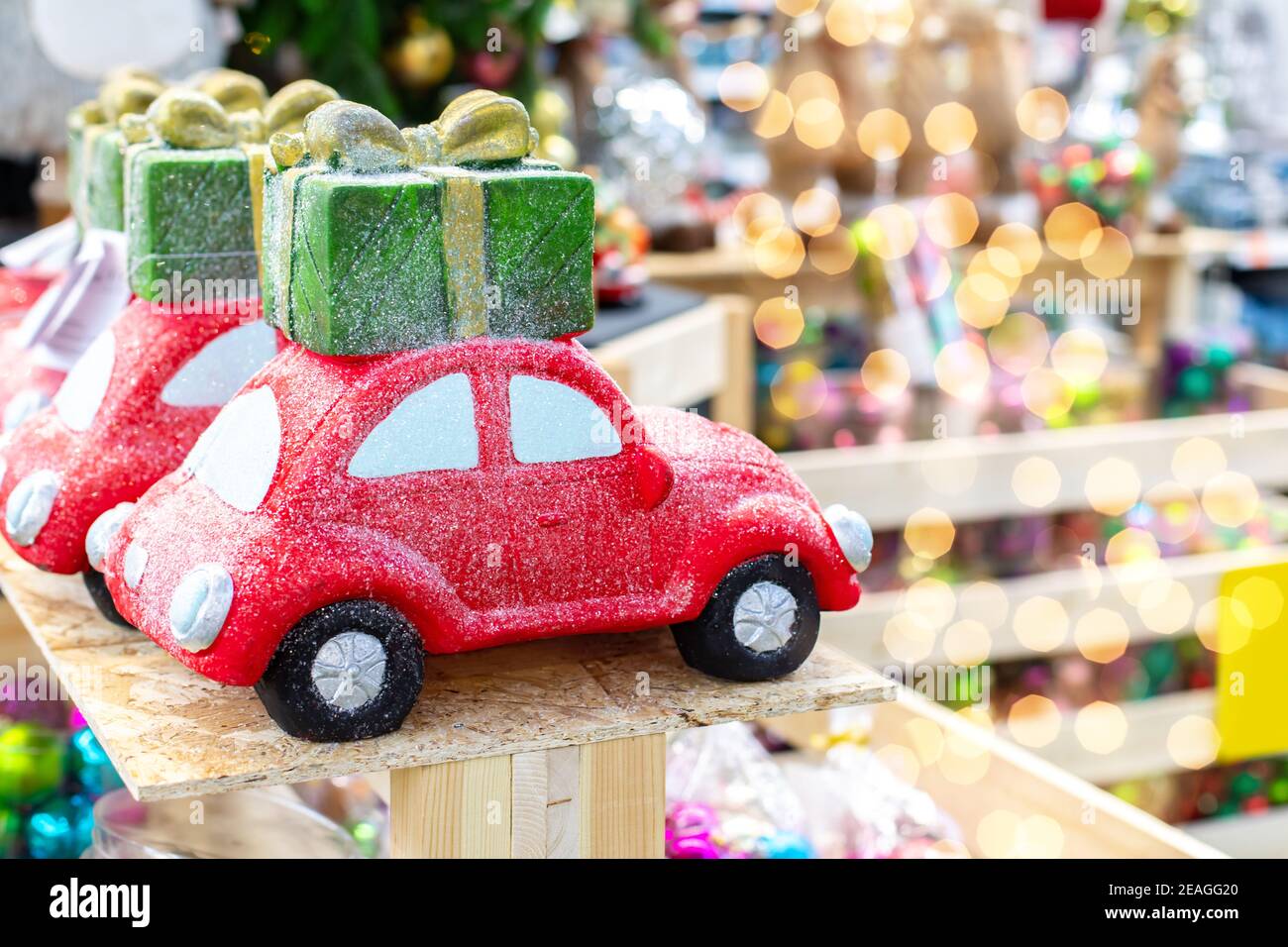 Rotes Spielzeugauto mit Geschenk auf dem Dach, Urlaubsbanner mit leuchtenden Highlights, Kopierraum Stockfoto