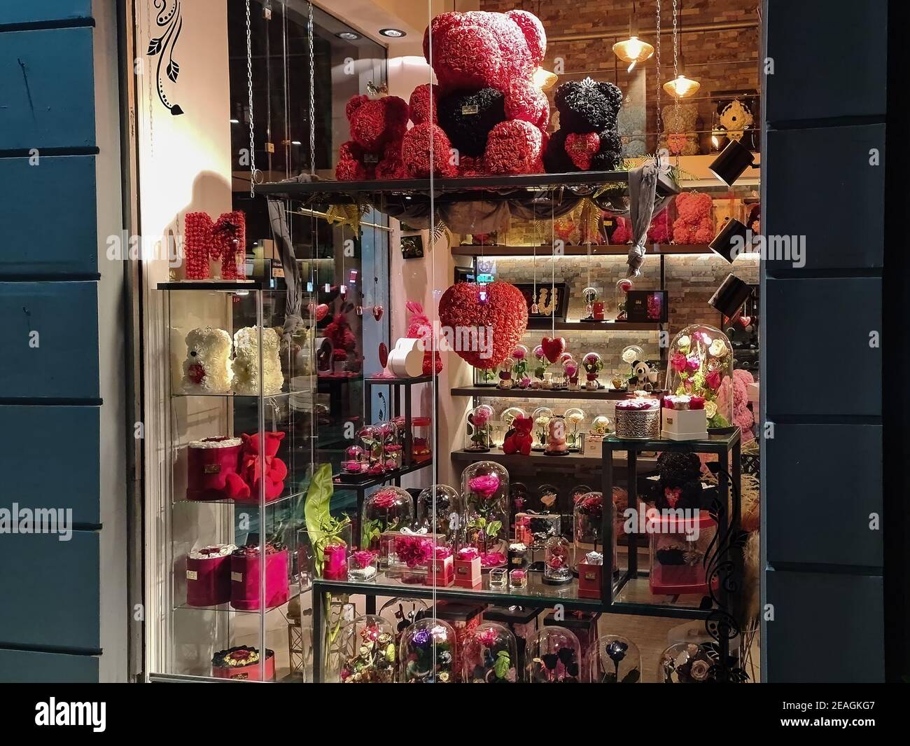 Thessaloniki, Griechenland – Januar 31 2021: Valentinstag Blumen Schaufenster. Beleuchtete Nachtansicht von Spielzeug Blume geformt Liebe Bären, Herzen und Geschenke für die jährliche Februar 14 Fest. Stockfoto