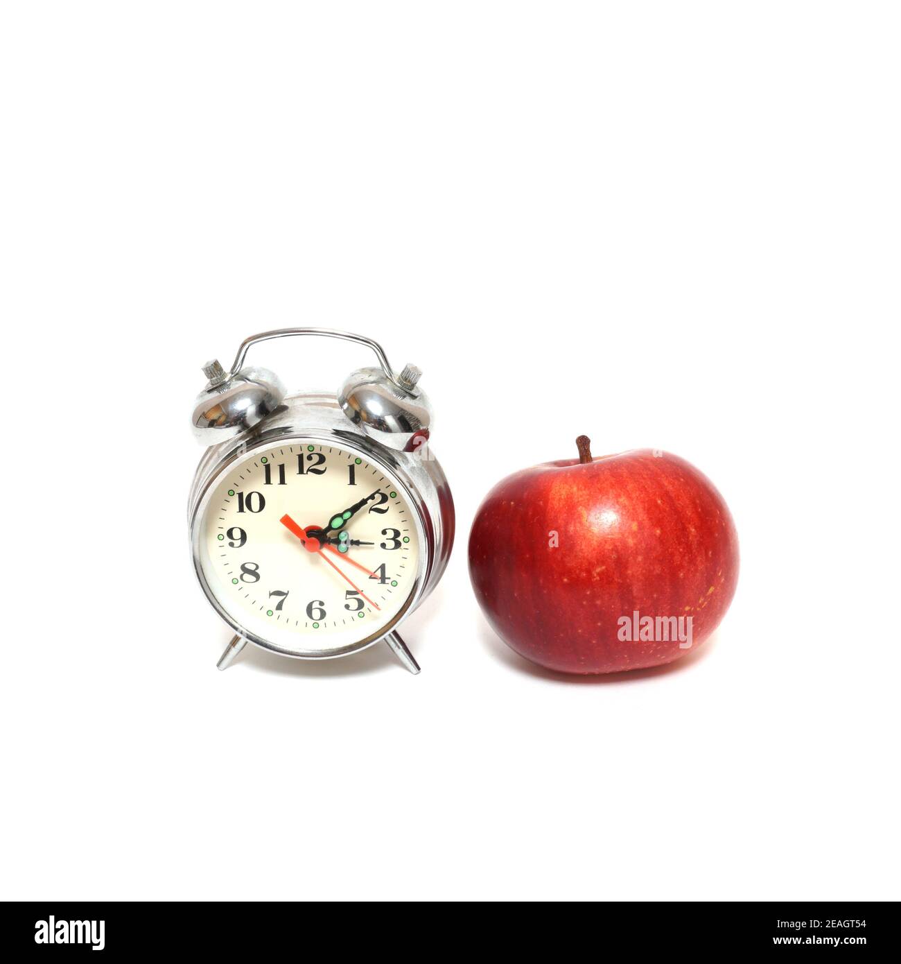 Roter Apfel und Uhr isoliert auf weißem Hintergrund, Zeitkonzept Stockfoto