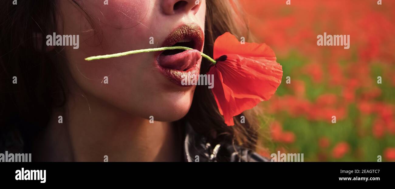 Frau mit Mohnblume in roten Lippen. Rote Flovers im Mund. Droge und Liebe, Opium, Mode. Schönheit, Sommer, Frühling, Mohn Feld Stockfoto