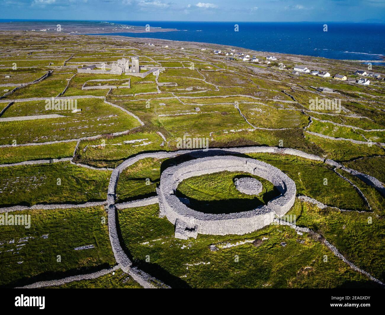 Dún Eochla. Stein für mit altem Leuchtturm im Hintergrund. Inishmore, Aran Island, Irland Stockfoto Dún Eochla. Stein für mit altem Leuchtturm im Hintergrund. Inishmore, Aran Island, Irland Stockfoto