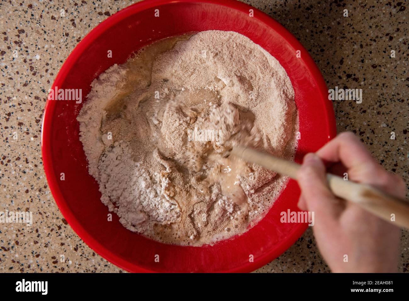 Wasser wird in eine Schüssel mit Mehl, Hefe und Salz gegeben. Serie Schritt-für-Schritt Herstellung hausgemachtes Brot. Bild 2 von 13 Stockfoto