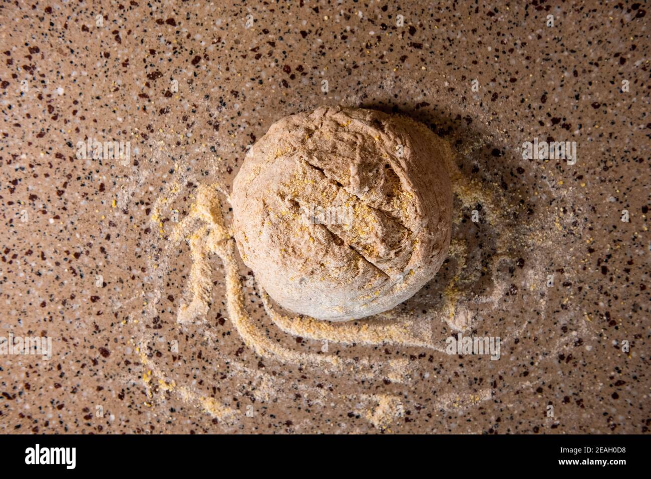 Eine Kugel Brotteig wird mit Maismehl bestäubt und Luftlöcher werden vor dem Backen in die Oberseite geschnitten. Serie Schritt-für-Schritt Herstellung hausgemachtes Brot. Rahmen 9 o Stockfoto