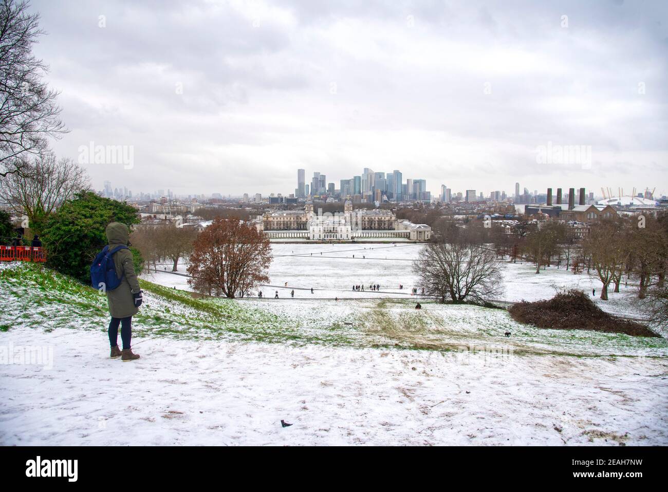 London, Großbritannien. Februar 2021, 09th. Eine Frau blickt auf den schneebedeckten Greenwich Park mit Canary Wharf in der Ferne. Kredit: SOPA Images Limited/Alamy Live Nachrichten Stockfoto