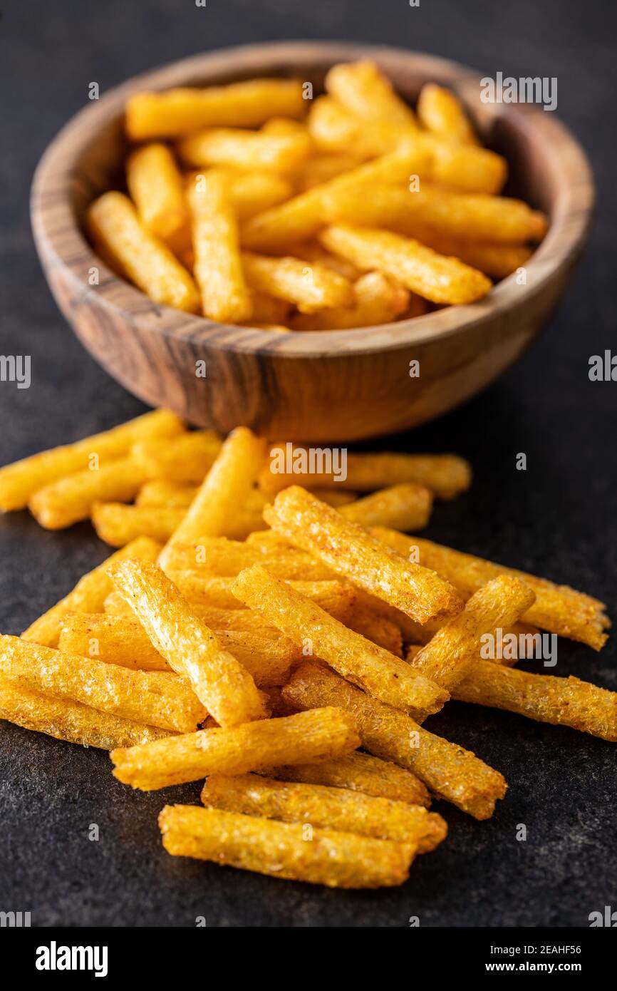 Pommes frites. Gesalzener Snack. Kartoffelchips auf schwarzem Tisch. Stockfoto