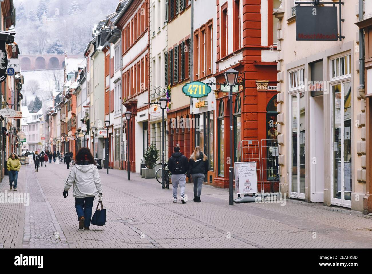 Heidelberg, Deutschland - Februar 2020: Historische Innenstadt am kalten Wintertag mit wenigen Leuten, die durch die Einkaufsstraße mit geschlossenen Geschäften schlendern Stockfoto