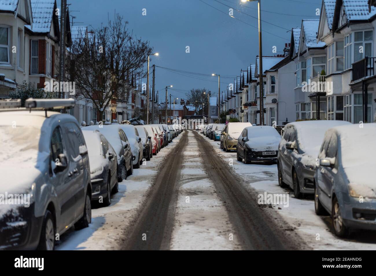 Hainault Avenue in Westcliff on Sea, Essex, Großbritannien, mit Schnee von Storm Darcy, der die Autos bedeckt. Vereister Weg in einem Wohngebiet, ungeklärt, am frühen Morgen Stockfoto