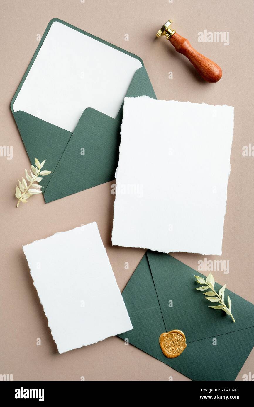 Elegante Hochzeit Schreibwaren Draufsicht. Flach legen leere Papierkarten, grüne Umschläge, Wachs Siegel Stempel auf braunem Hintergrund. Stockfoto