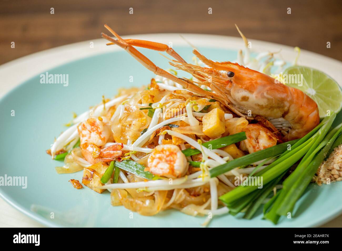 Nahaufnahme von köstlichen asiatischen Speisen, Hot Fresh Shrimp Pad Thai Nudelgericht garniert mit Krebse Frühlingszwiebeln und Limette Stockfoto