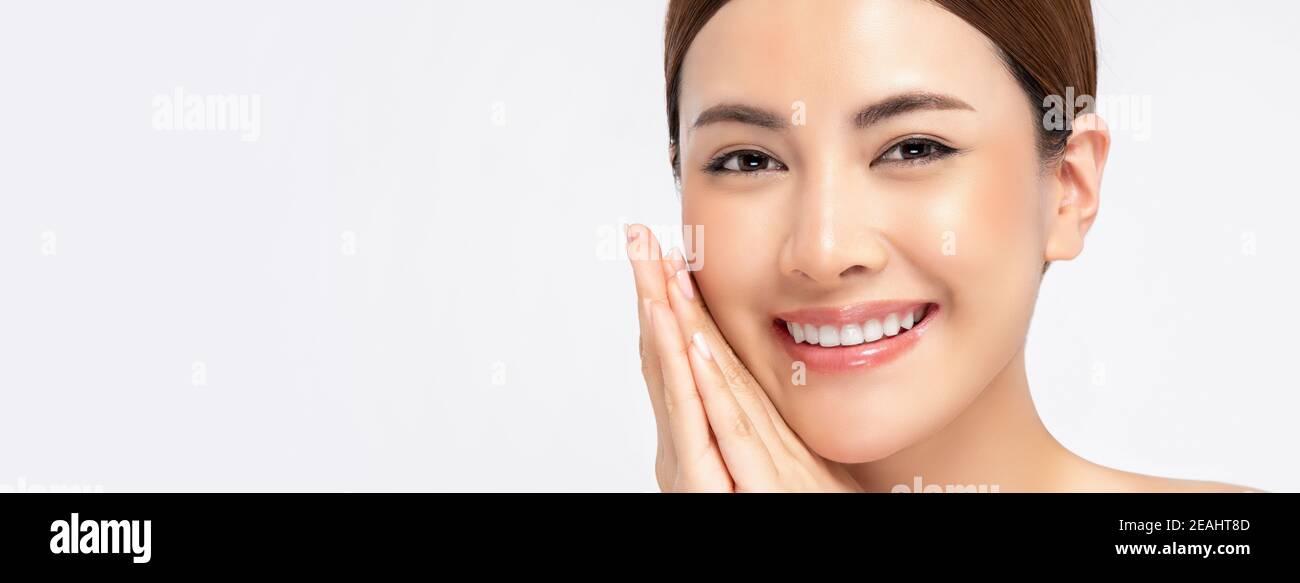 Jugendliche strahlende Haut asiatische Frau lächelnd mit Händen berühren Gesicht Isoliert auf weißem Banner-Hintergrund mit Platz zum Kopieren für Schönheit Konzept Stockfoto