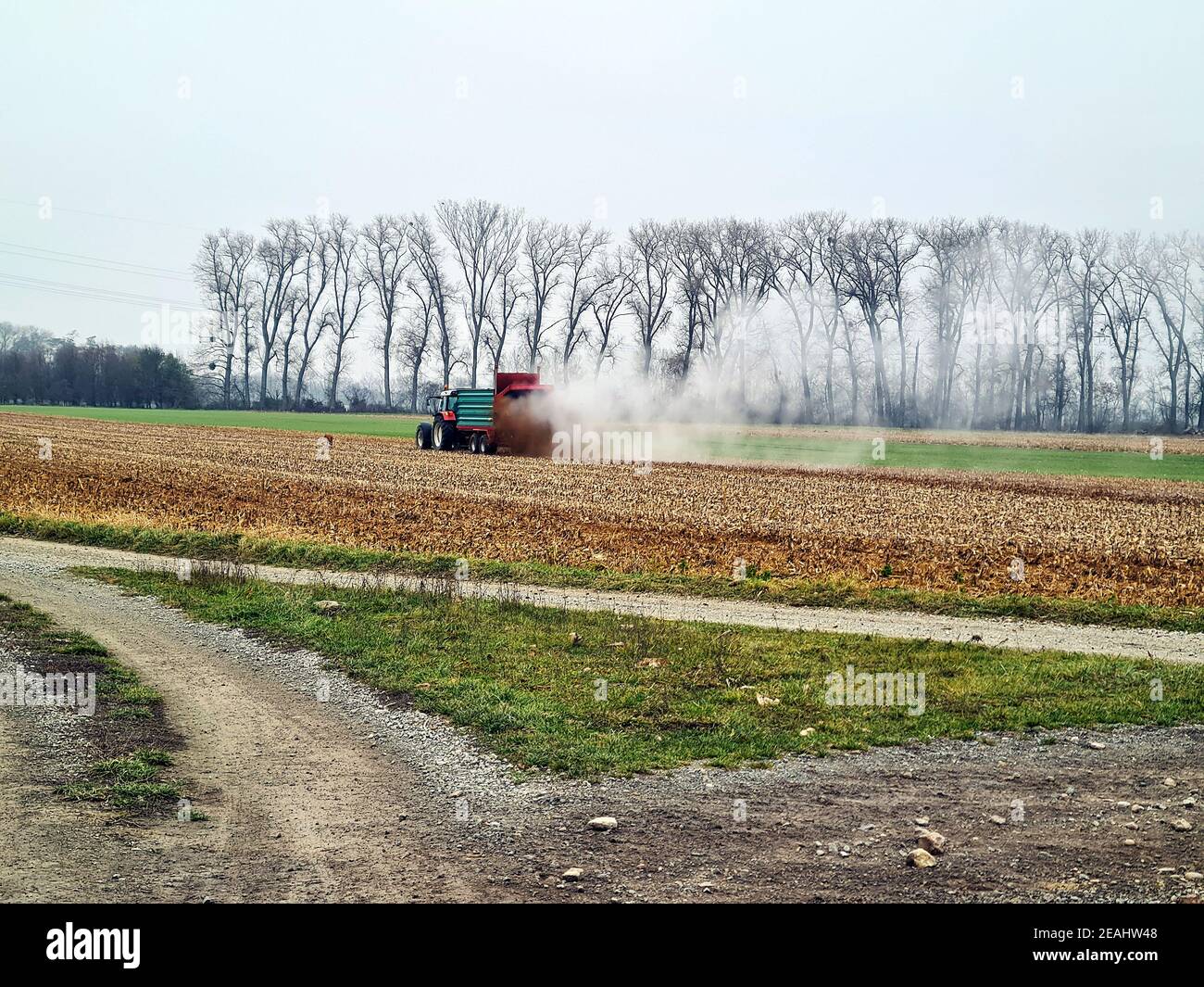REISENBERG, ÖSTERREICH - 27. NOVEMBER 2019: Unidentifizierter Landwirt auf Traktor durch landwirtschaftliche Feldarbeit, Aufsprühen von Gülle auf einem Feld Stockfoto