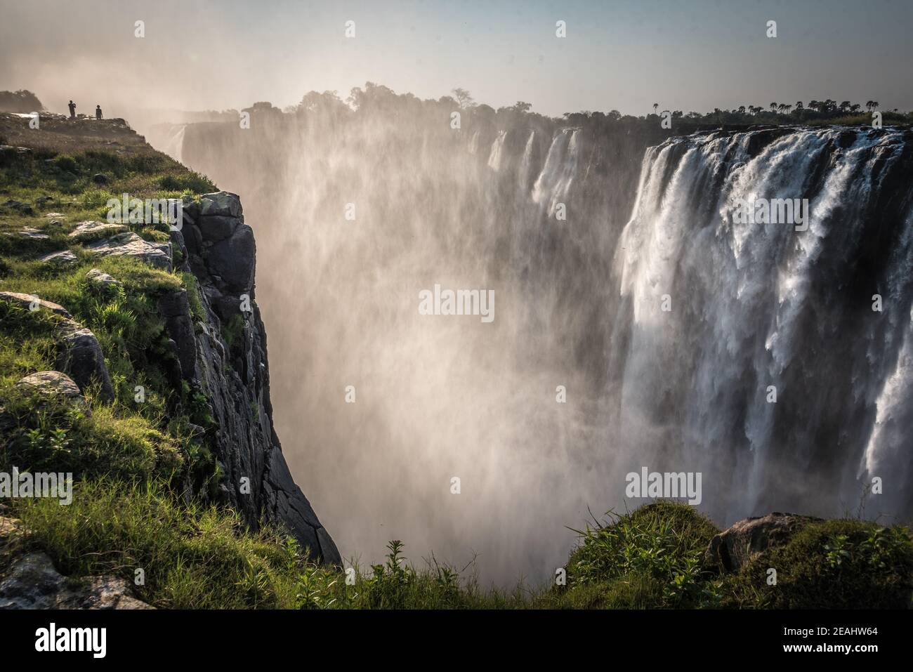 Victoria Falls mit zwei Menschen am Rande, am Abend, Foto in Sambia Stockfoto