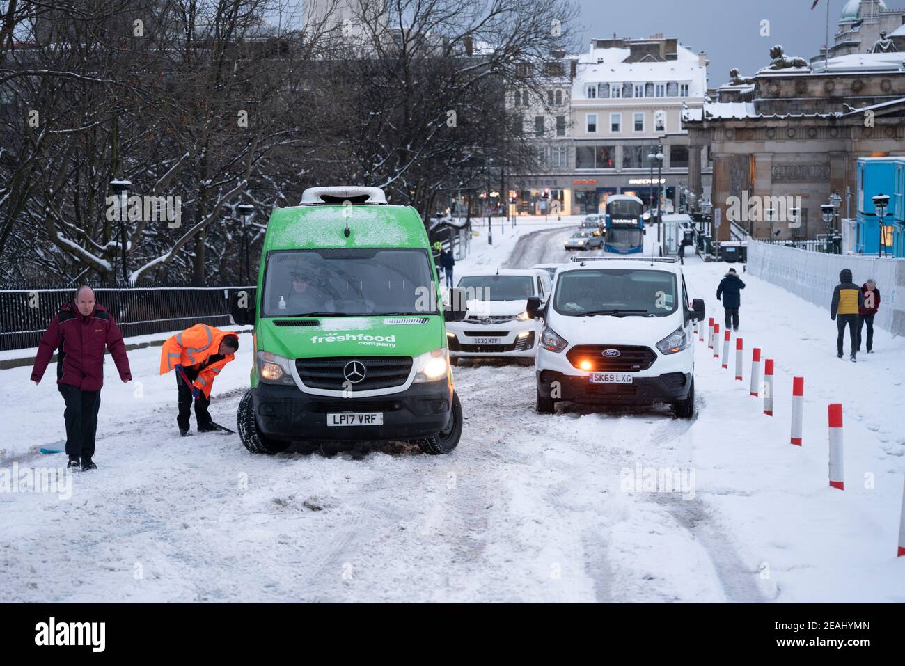 Edinburgh, Schottland, Großbritannien. Februar 2021, 10. In Großbritannien setzt sich der große Frost fort, und der schwere Schnee über Nacht und Morgen bringt den Verkehr auf vielen Straßen im Stadtzentrum zum Stillstand. PIC; Menschen frei Autos auf dem Hügel stecken. Iain Masterton/Alamy Live Nachrichten Stockfoto