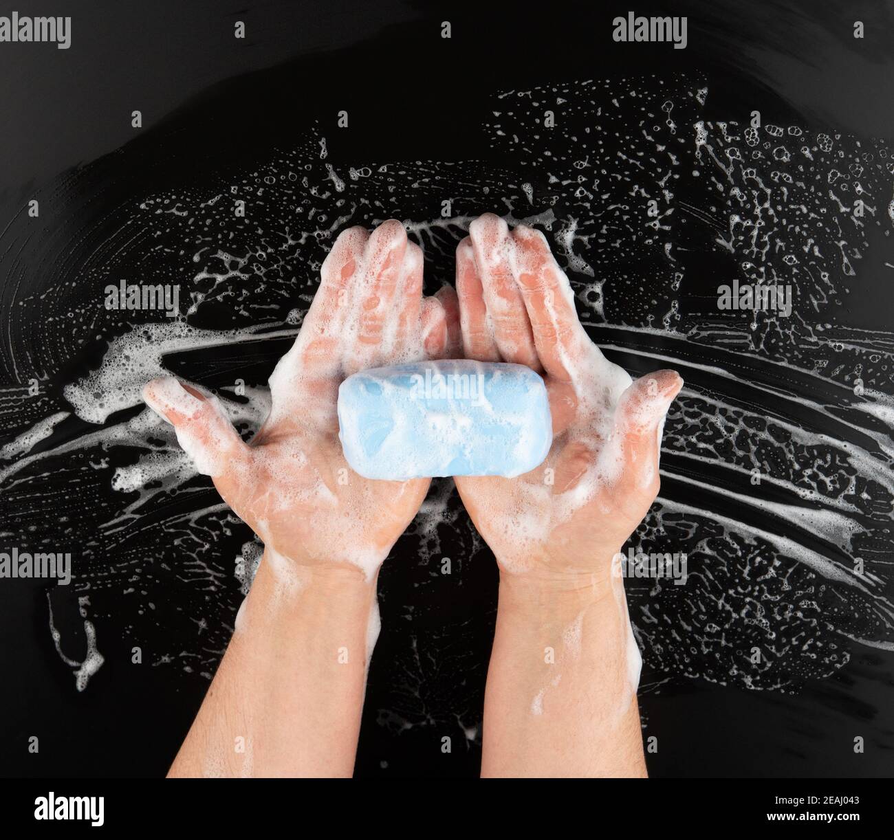 Prozess der Händewaschen mit blauer Seife, Teile des Körpers in weißem Schaum auf schwarzem Hintergrund Stockfoto