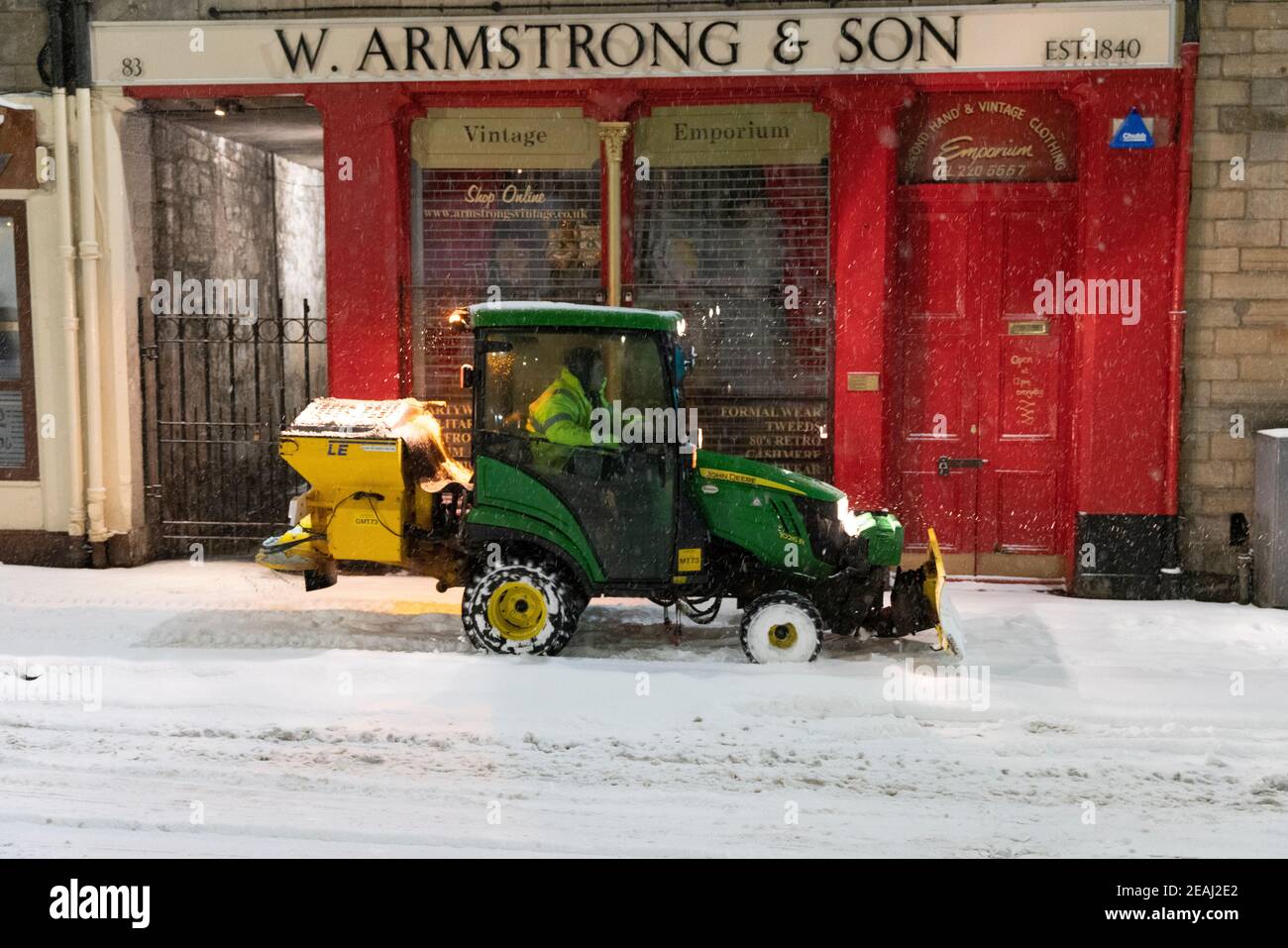 Edinburgh, Schottland, Großbritannien. Februar 2021, 10. In Großbritannien setzt sich der große Frost fort, und der schwere Schnee über Nacht und Morgen bringt den Verkehr auf vielen Straßen im Stadtzentrum zum Stillstand. PIC; kleiner Traktor Schneepflug und Gitter auf dem Bürgersteig in Grassmarket . Iain Masterton/Alamy Live Nachrichten Stockfoto