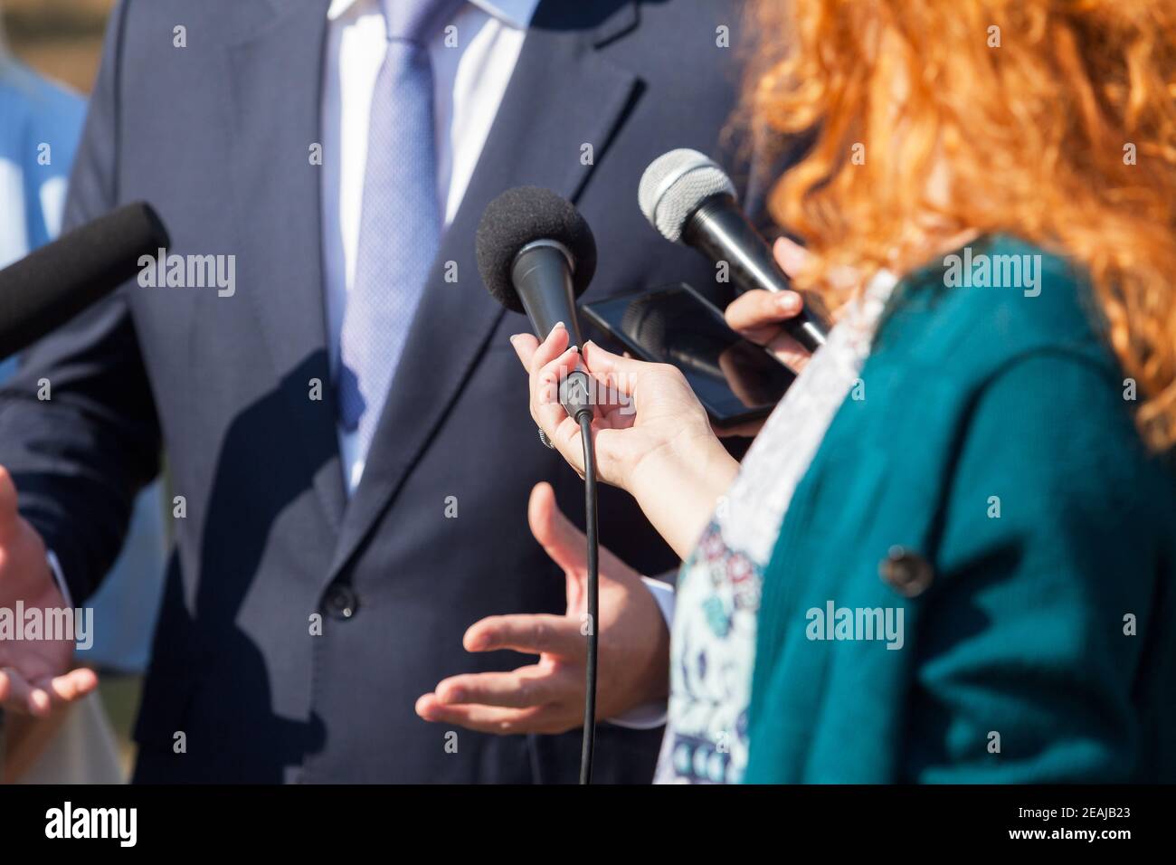 Reporter führen ein Medieninterview mit Geschäftspolitikerin oder Politiker durch Stockfoto