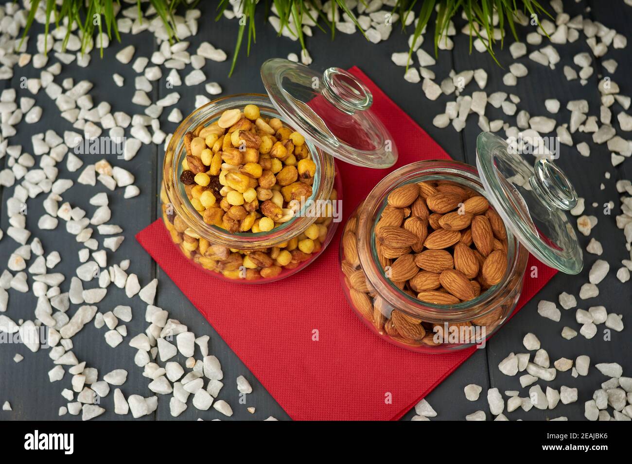 Geschälte Mandeln und gemischte Nüsse in zwei Gläsern. Nahrhafte Snacks Stockfoto
