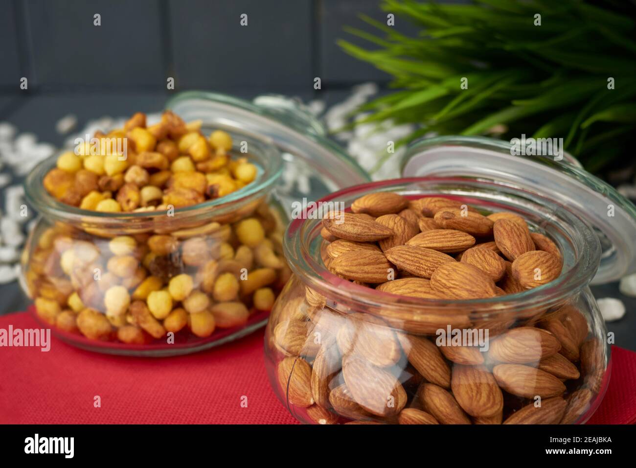Gläser mit Snacks. Ungeschälte natürliche Mandeln und verschiedene Nüsse. Stockfoto