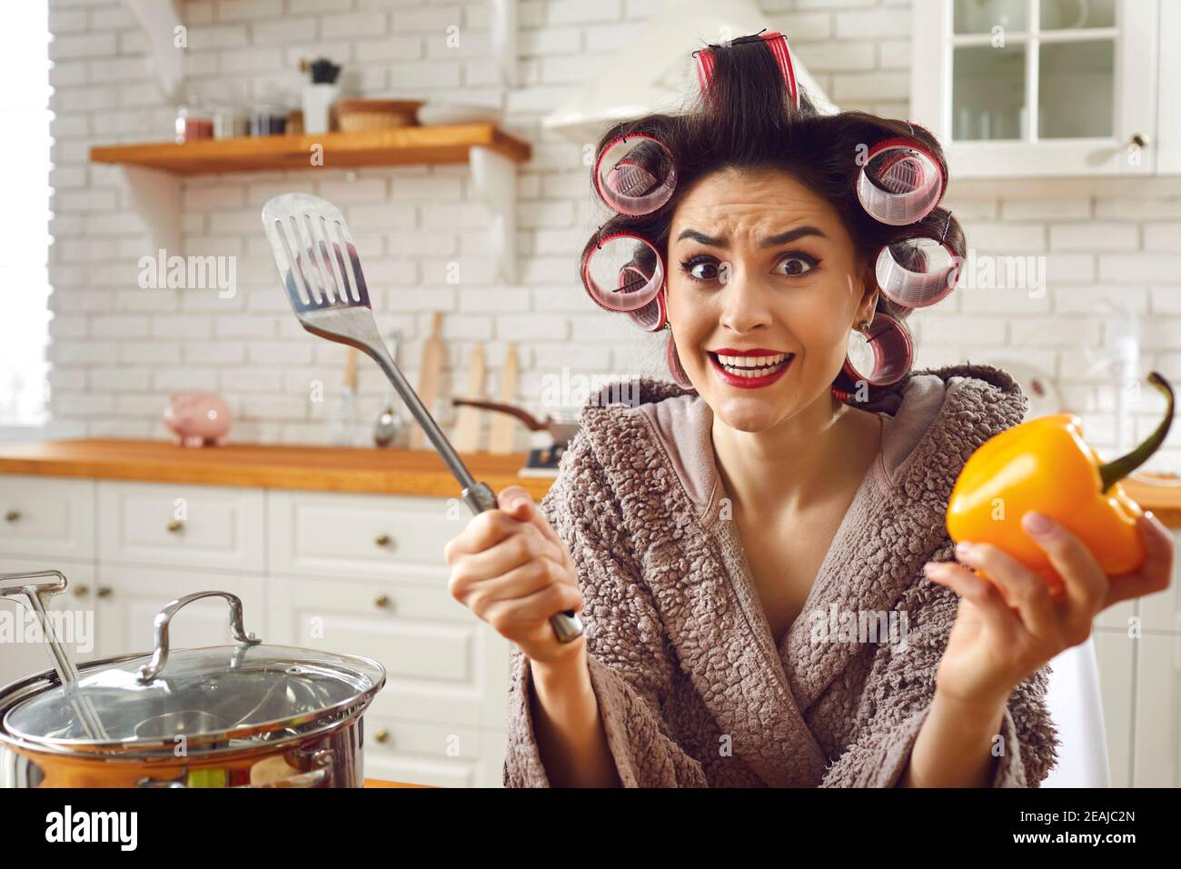 Lustige unerfahrene Hausfrau Gefühl gestresst und hilflos beim Kochen ein Mahlzeit Stockfoto