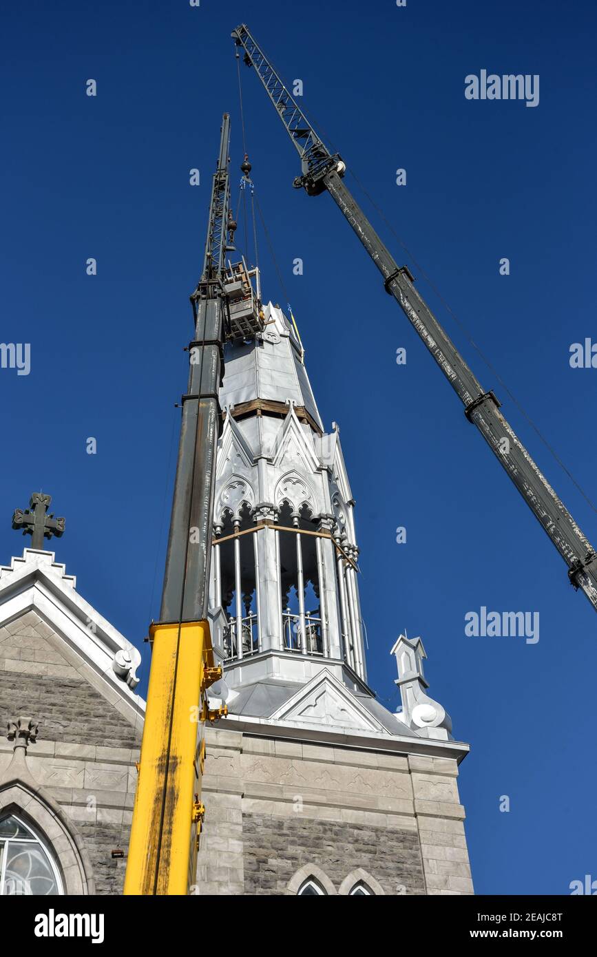 Reparatur des Kirchturm der Kirche Saint-Pie in Quebec mit zwei Kränen Stockfoto