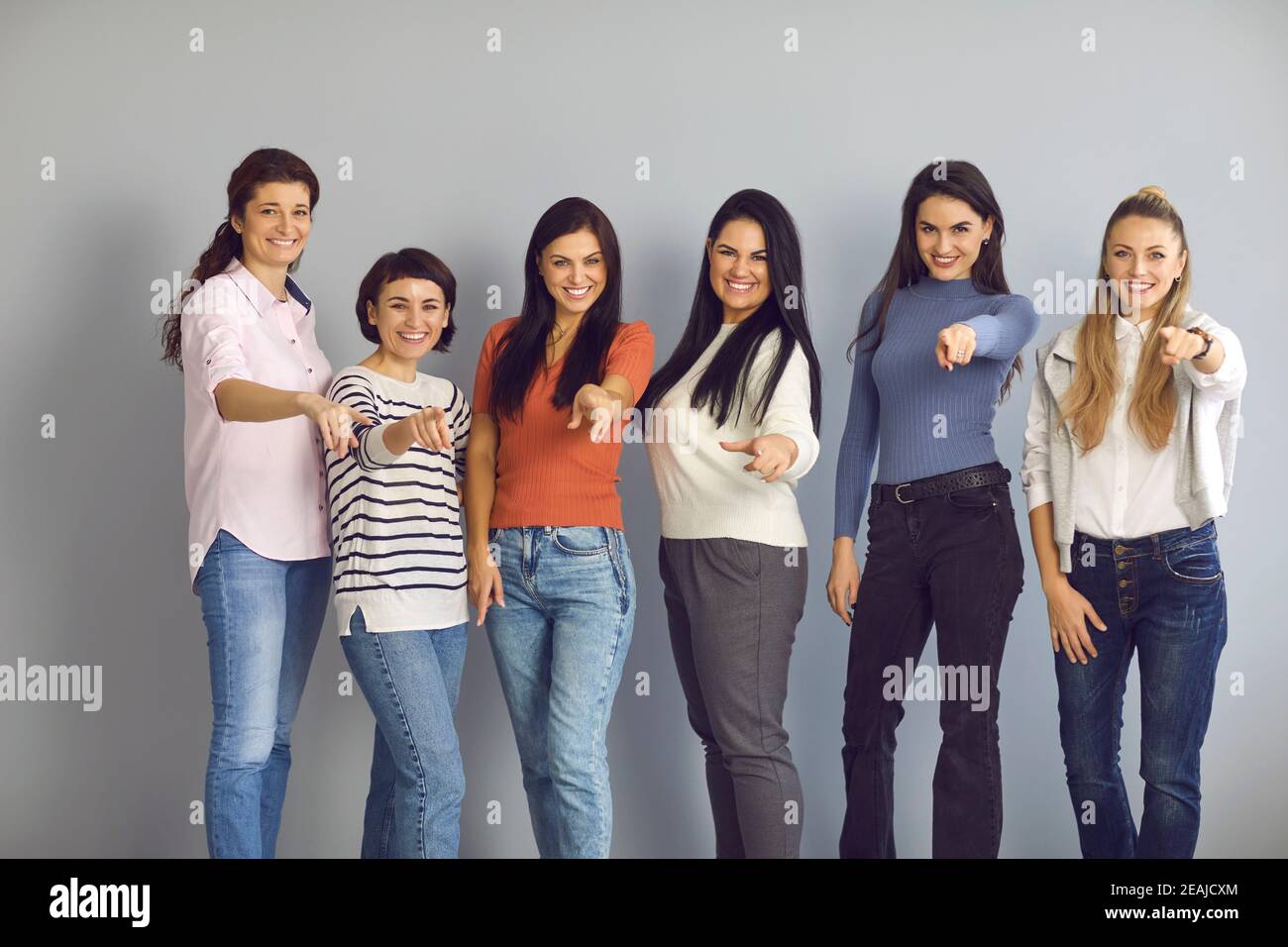 Gruppe lächelnder Frauen, die auf die Kamera zeigen und Sie einladen, sich ihrem erfolgreichen Team anzuschließen Stockfoto