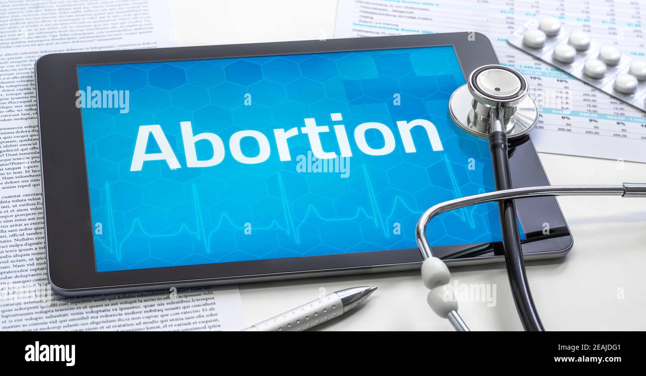 Das Wort Abtreibung auf dem Display einer Tablette Stockfoto