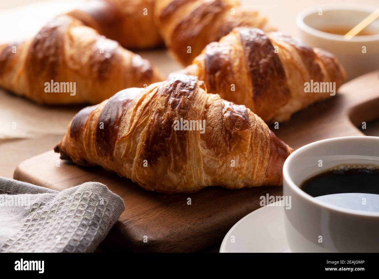 Croissants und Kaffee auf einem Holzbrett Stockfoto