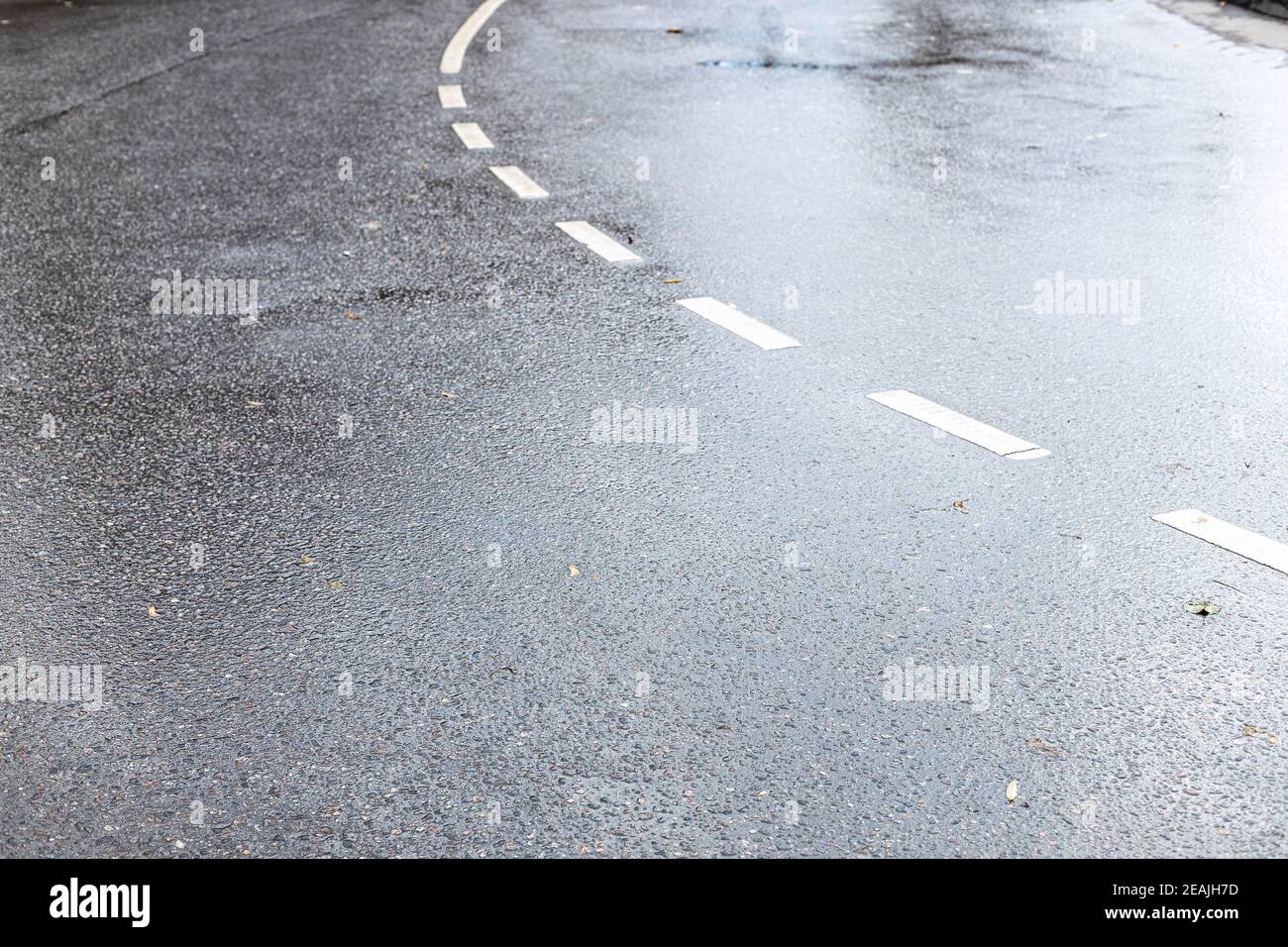Nasse Oberfläche der zweispurigen Straße nach Herbstregen Stockfoto