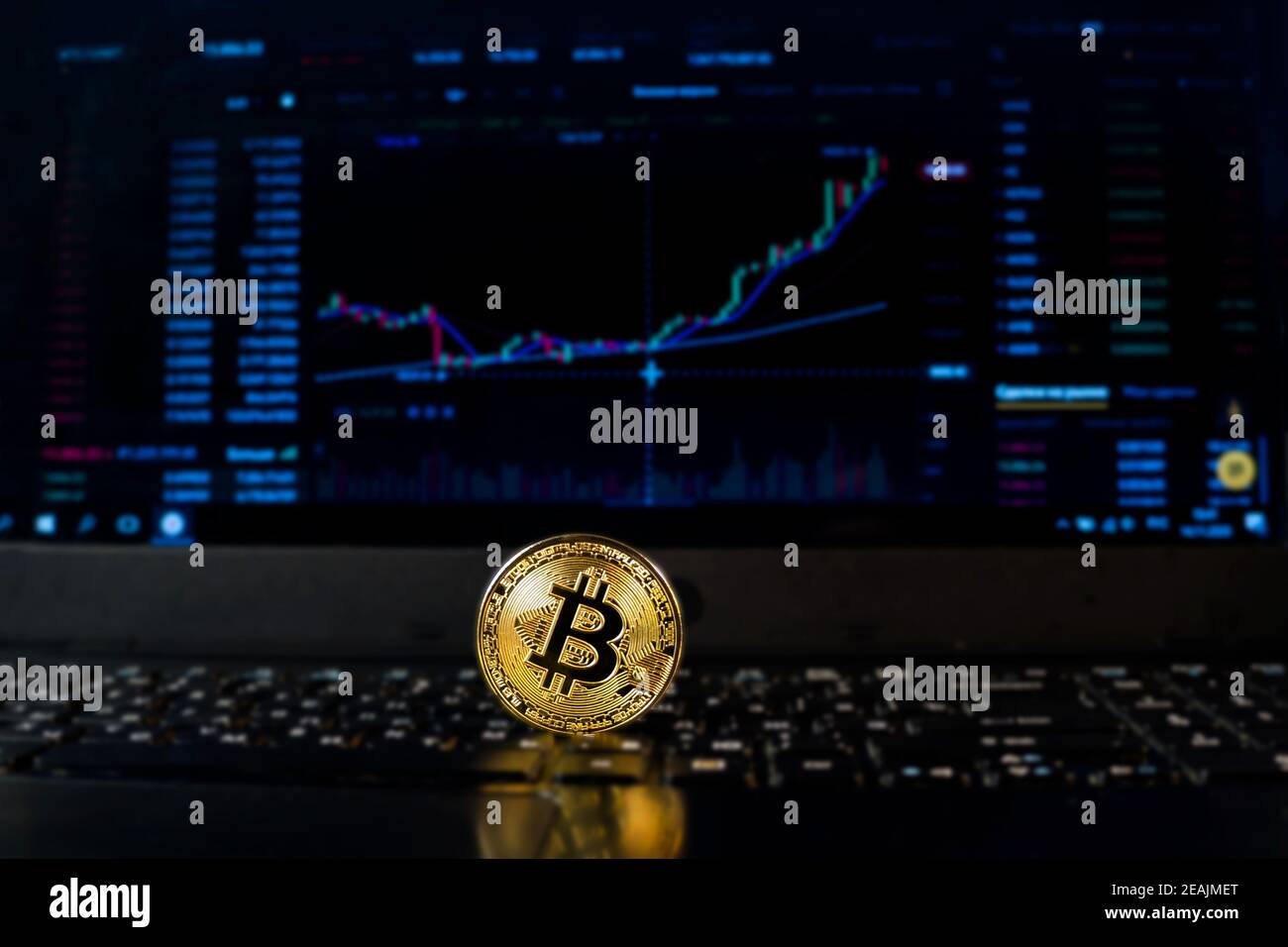 Eine Bitcoin-Münze auf dem Hintergrund eines Diagramms, das den Kurs auf einer Wechselstube oder einem Forex anzeigt. Bitcoin-Wechselkurs, elektronisches Geld oder Währung. Stockfoto