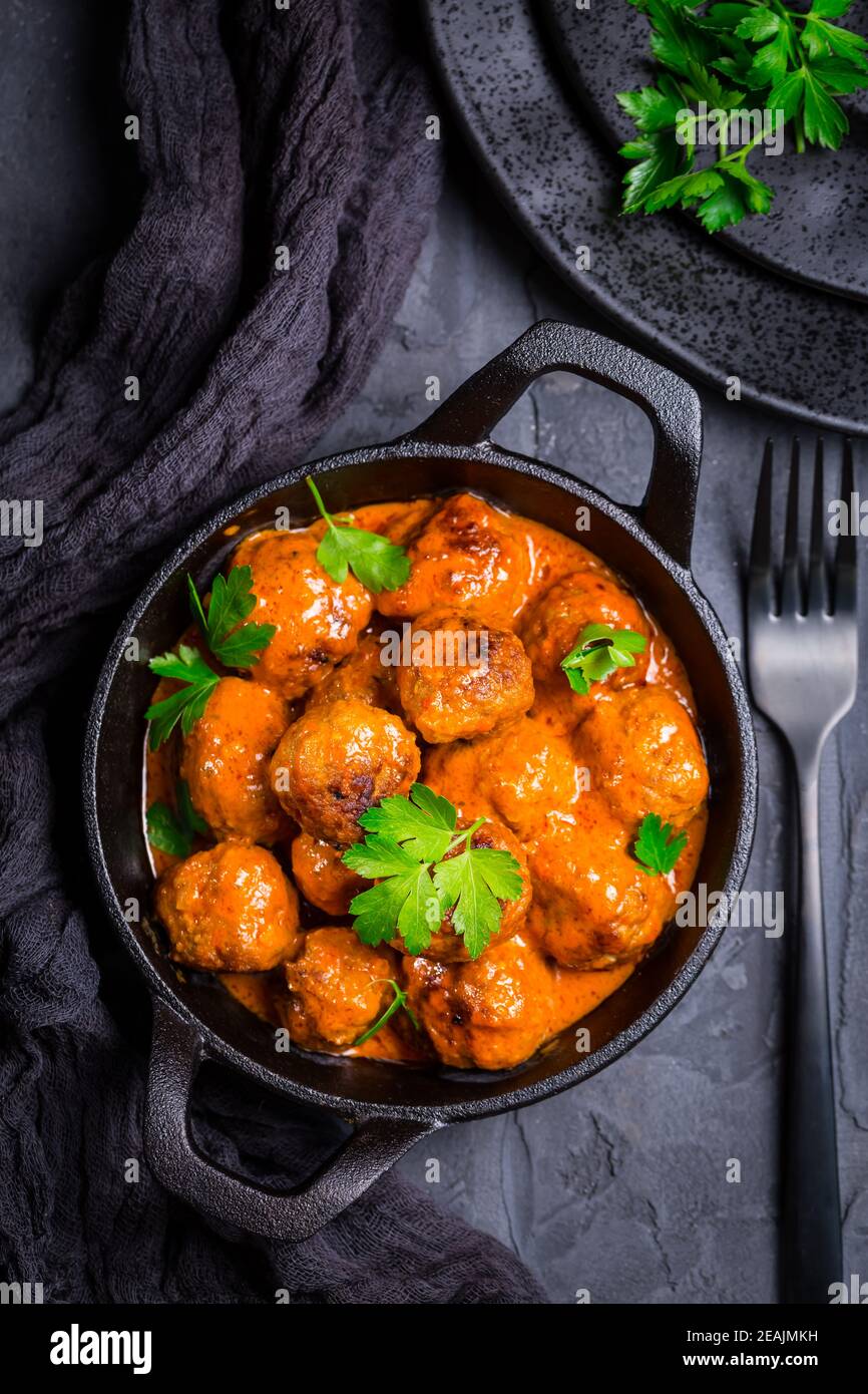 Fleischbällchen mit Tomatensauce in schwarzer Pfanne Stockfoto