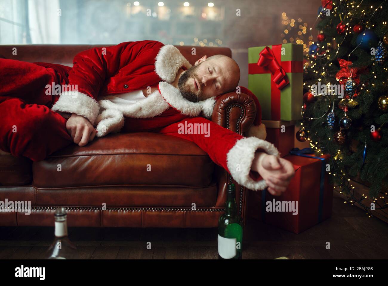 Schlecht betrunkener weihnachtsmann schläft auf dem Sofa nach der Party Stockfoto