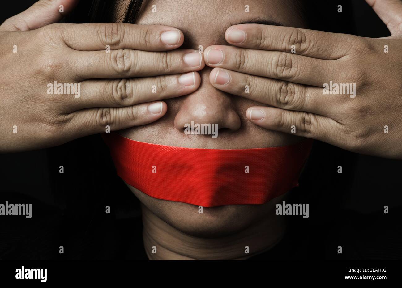 Asiatische Frau Augenbinde wickeln Mund mit rotem Klebeband Stockfoto