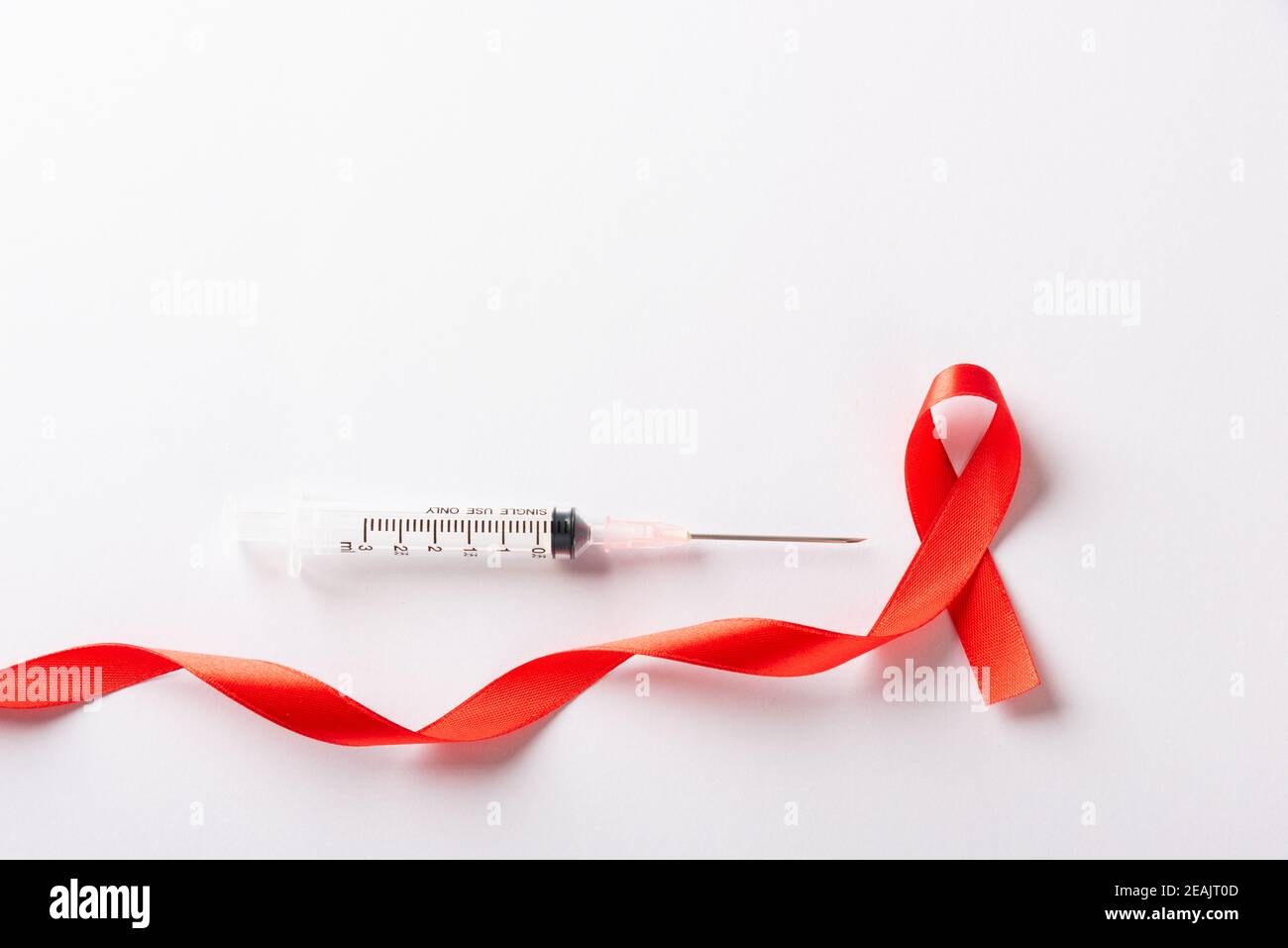 Rotes Schleife Symbol HIV, AIDS Krebs Bewusstsein und Spritze Stockfoto