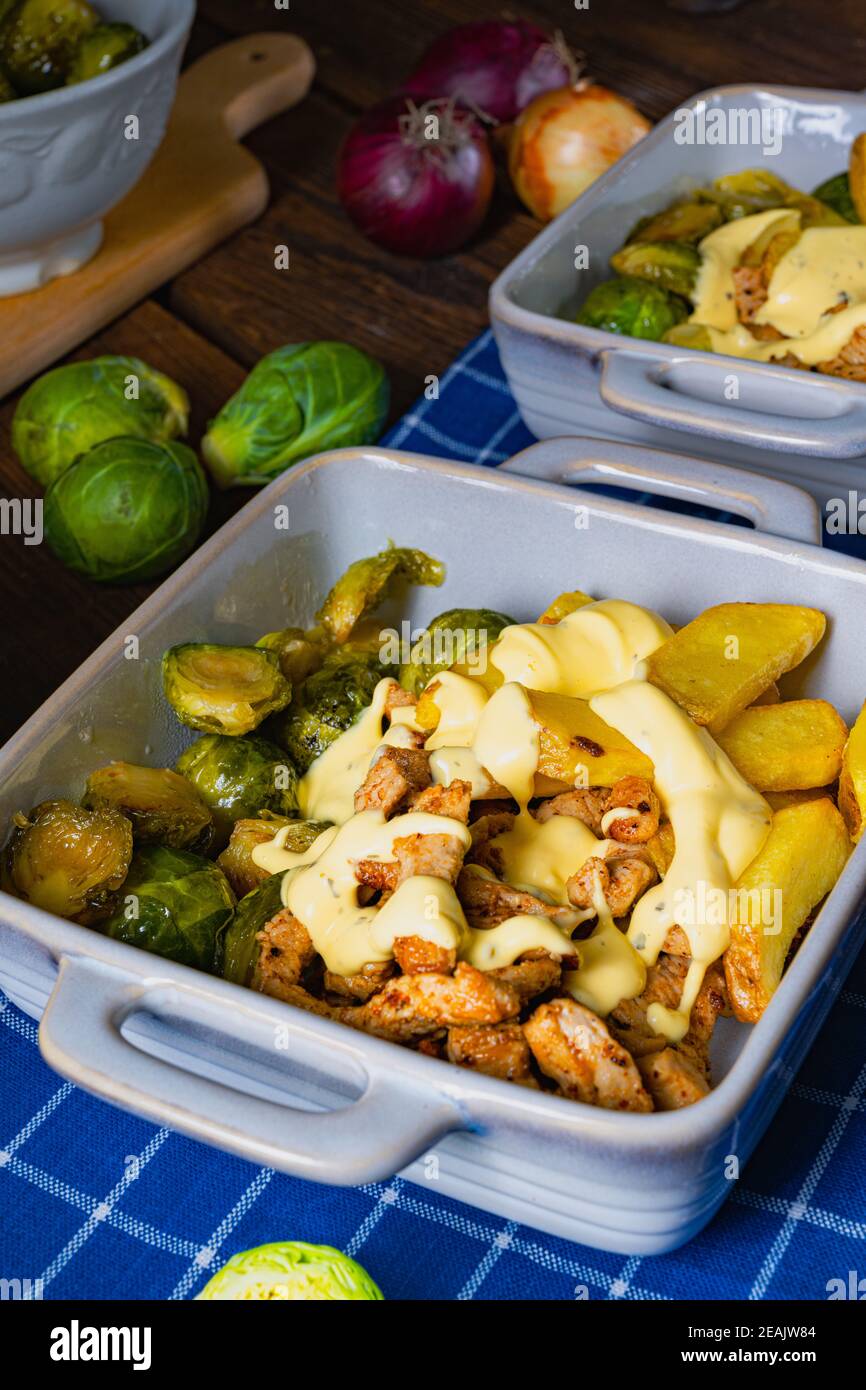 Gratiniertes Zürichragout mit Rosenkohl, Kartoffeln und Bearnaise-Sauce Stockfoto