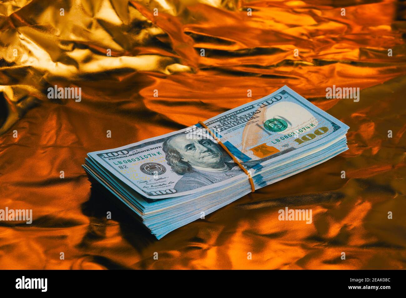 Ein großer Dollar-Wad auf goldenem Hintergrund. Stockfoto