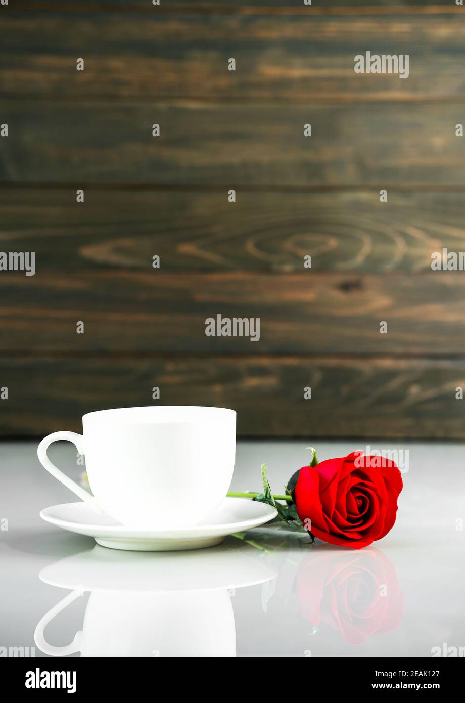 Rote Rosen und Kaffeetasse auf Tisch mit Kopierfläche Stockfoto