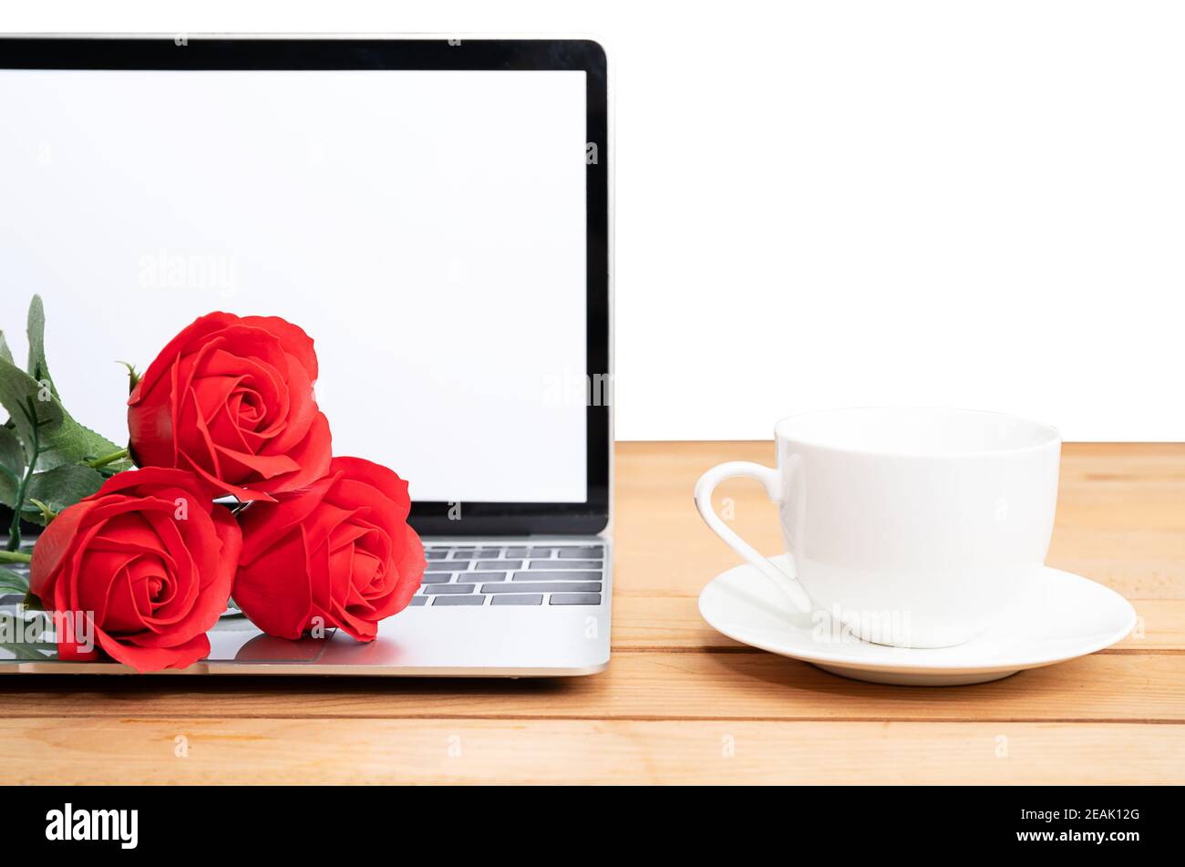 Rote Rose und Kaffeetasse mit Laptop-Mockup auf weiß Stockfoto