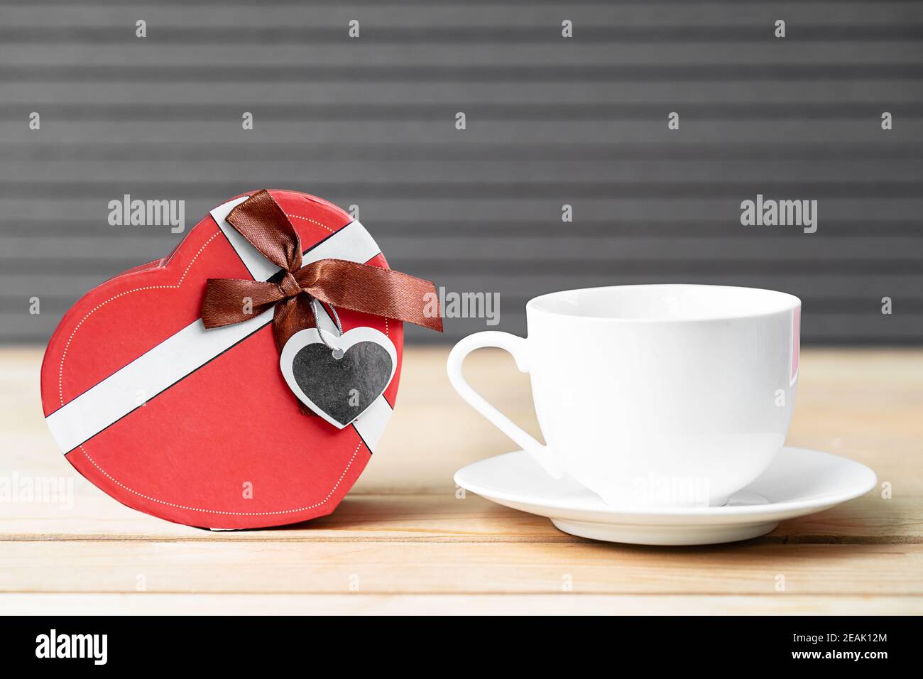 Rote Rosen und Kaffeetasse auf Holz Hintergrund Stockfoto