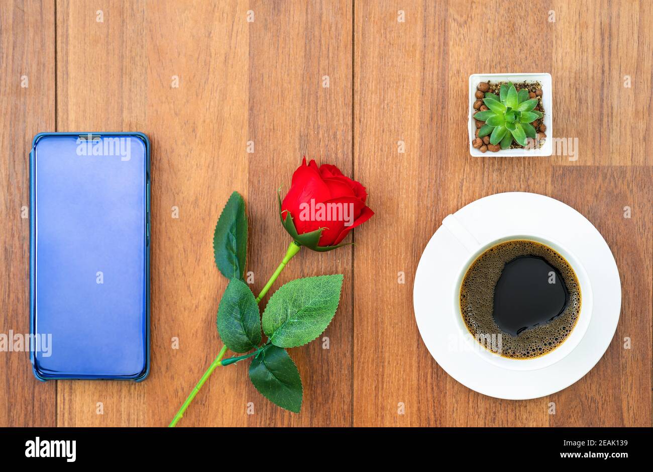 Weiße Tasse Kaffee und rote Rose mit Handy valentine Konzept Stockfoto