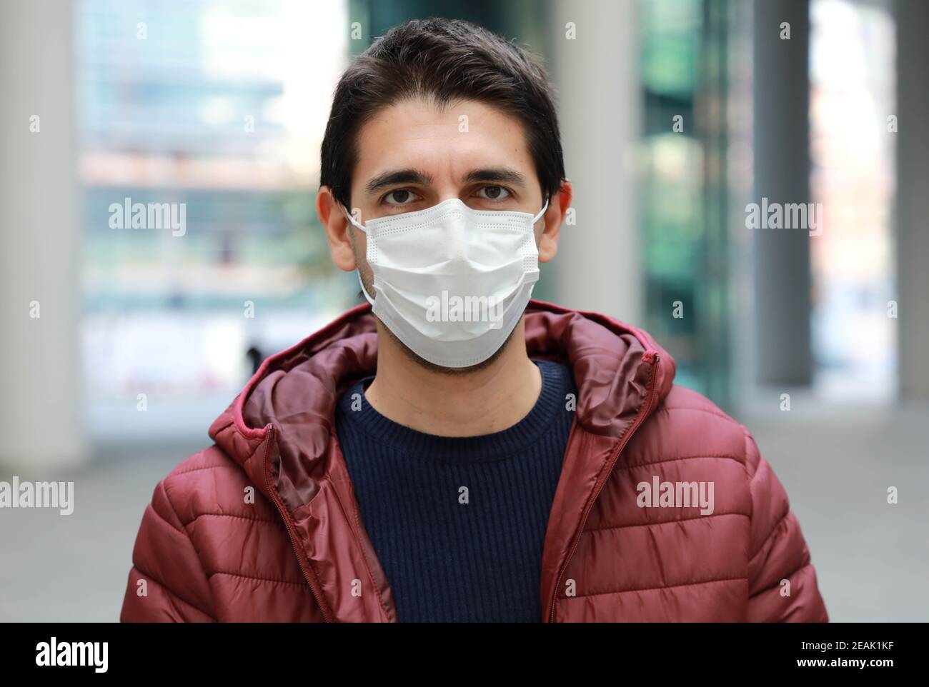 Porträt von besorgten Mann in der modernen Stadt Straße trägt Schutz Gesichtsmaske Stockfoto